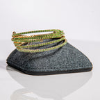 August peridot birthstone bangles in gold with olive-green crystals stacked to show flexible fit