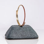 January garnet birthstone bangle in gold showing red crystals on flexible one-size-fits-most design