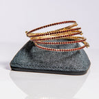 January garnet birthstone bangles in gold stacked to show flexible memory wire and premium crystal construction