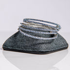 March aquamarine birthstone bangles in silver with sea-blue crystals stacked showing flexible design