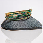 May emerald birthstone bangles in gold with green crystals stacked to show one-size-fits-most design