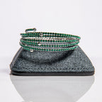 May emerald birthstone bangles in silver with lush green crystals stacked showing flexible design